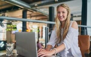 blogging tools for beginners smiling woman on a silver laptop