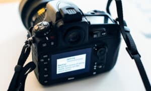 Display of Nikon DSLR Camera Professional updating firmware with message on the screen: Do not turn camera off during update