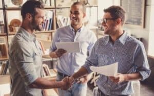 partners in a partnership agreement 3 men wearing different blue shirts