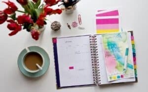 best planners for bloggers planner open with red flowers and coffee cup